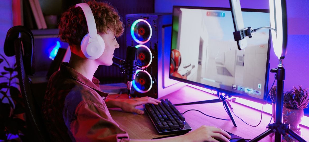 Caucasian Teenager Boy Wearing Headphones Gaming and Streaming Online at Desk